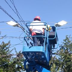 Trabajador en una plataforma elevadora instalando luminarias